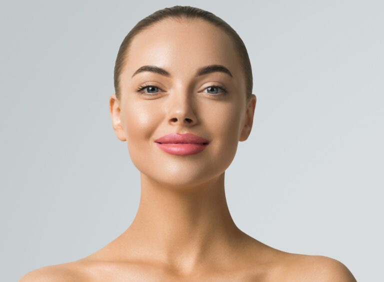 Clean skin woman face close up skin beauty tanned face beautiful smile over blue background